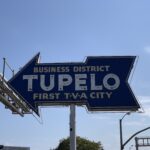 neon arrow sign that says "Tupelo"